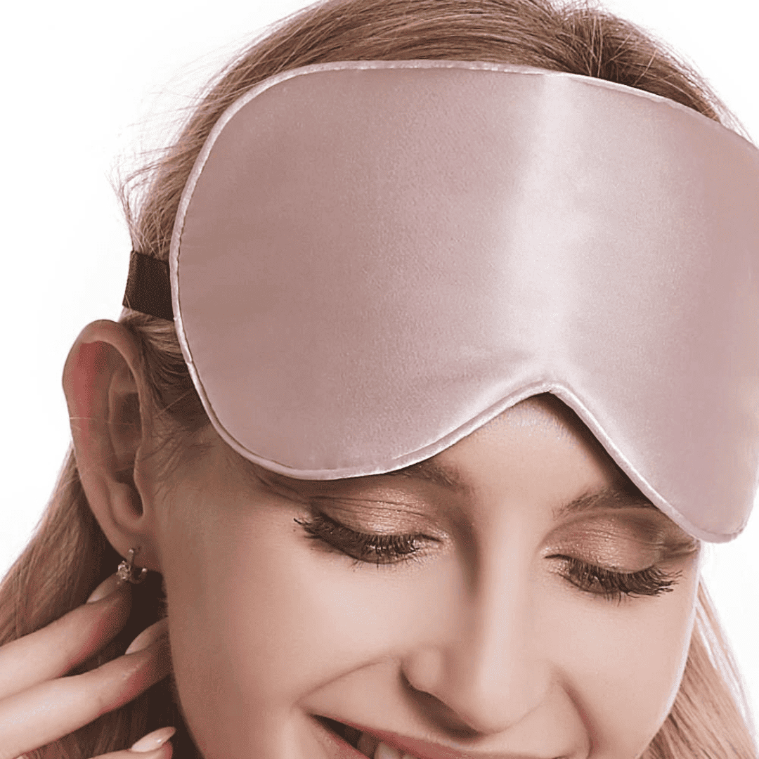 femme qui porte un masque de nuit en soie rose sur ses cheveux