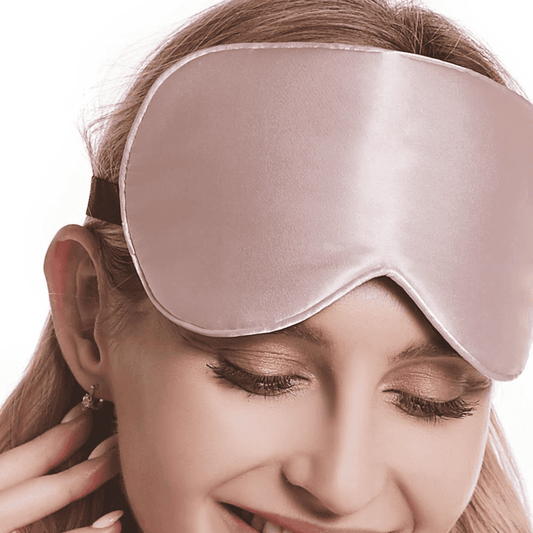 femme qui porte un masque de nuit en soie rose sur ses cheveux